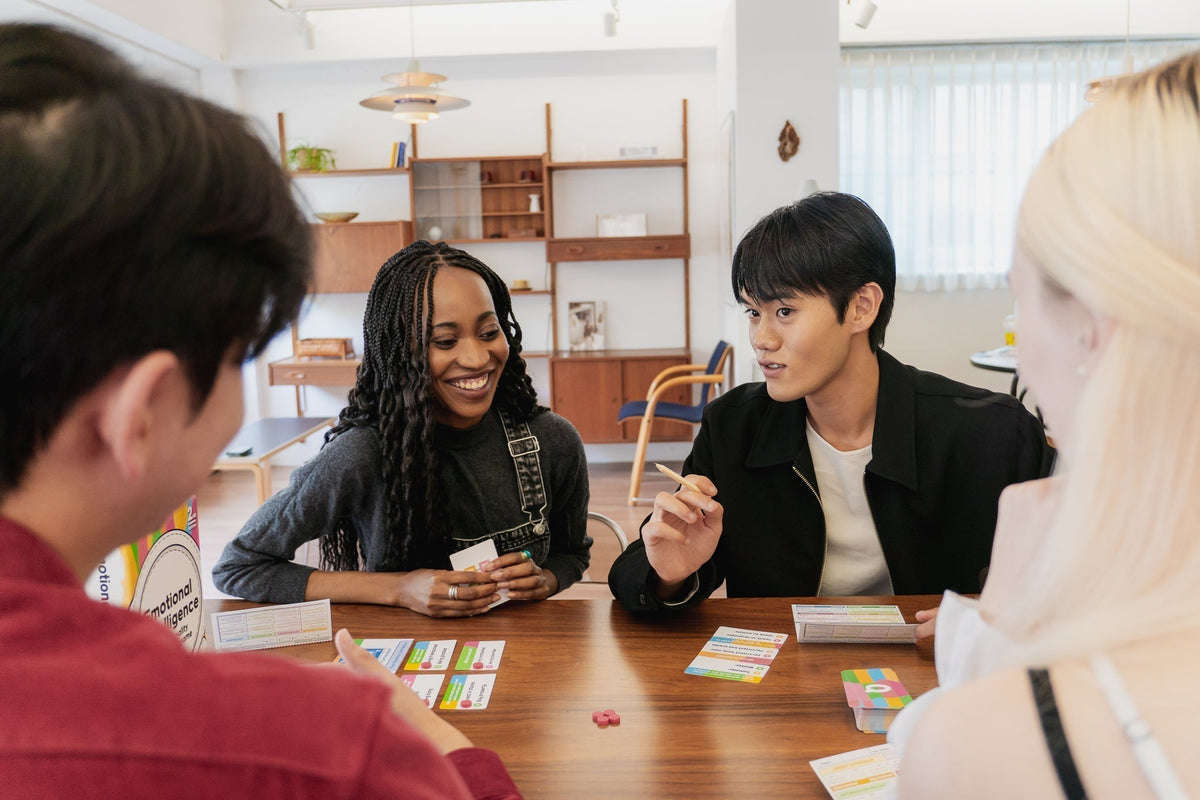 Friends gathered around a table playing games during family game night